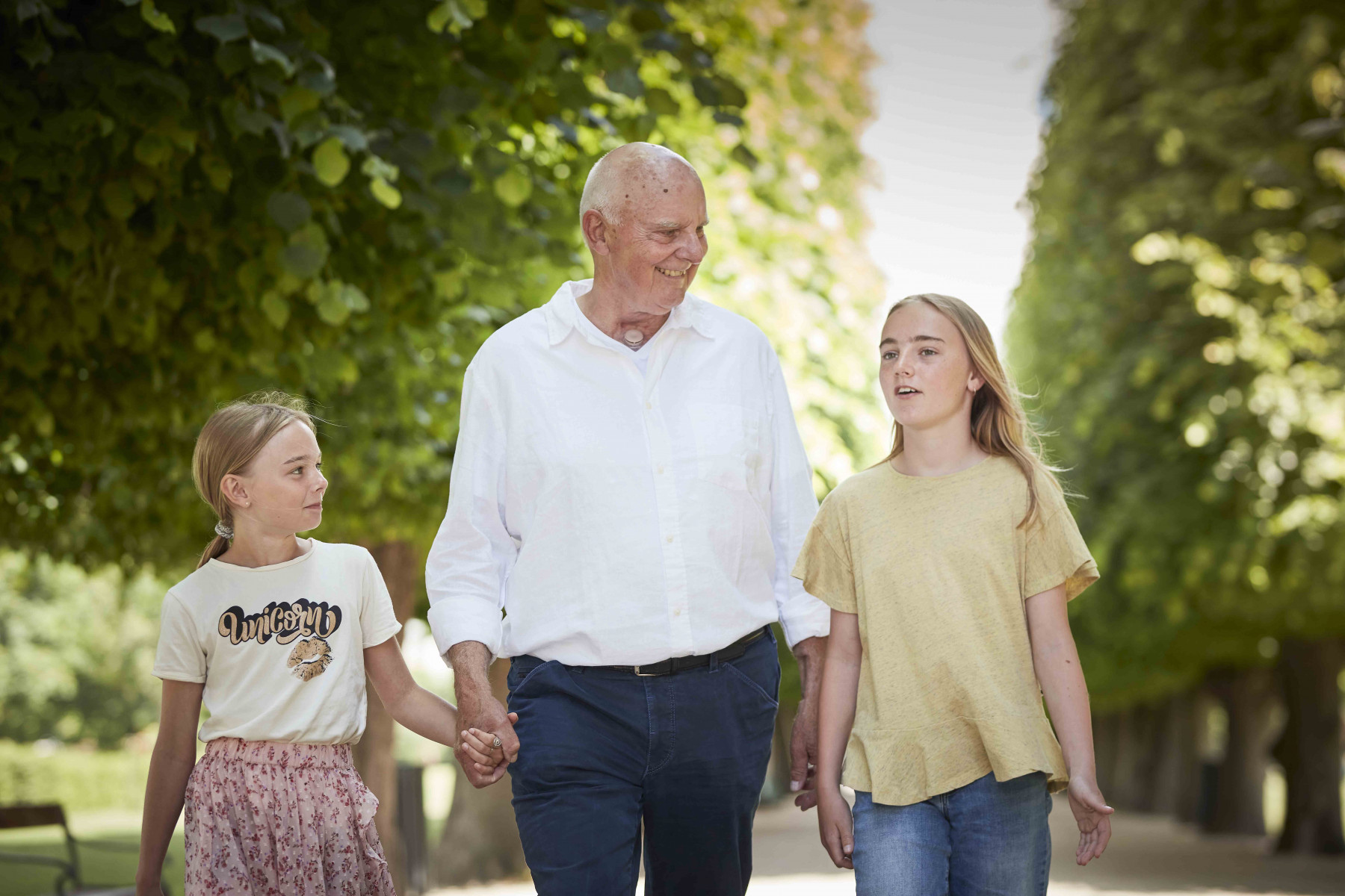 family walking outside man with laryngectomy stoma and grandchildren